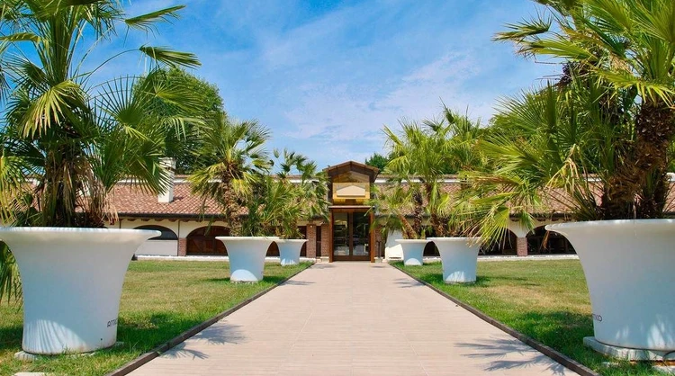 Ingresso del Golf Club Cà della Nave con viale e palme